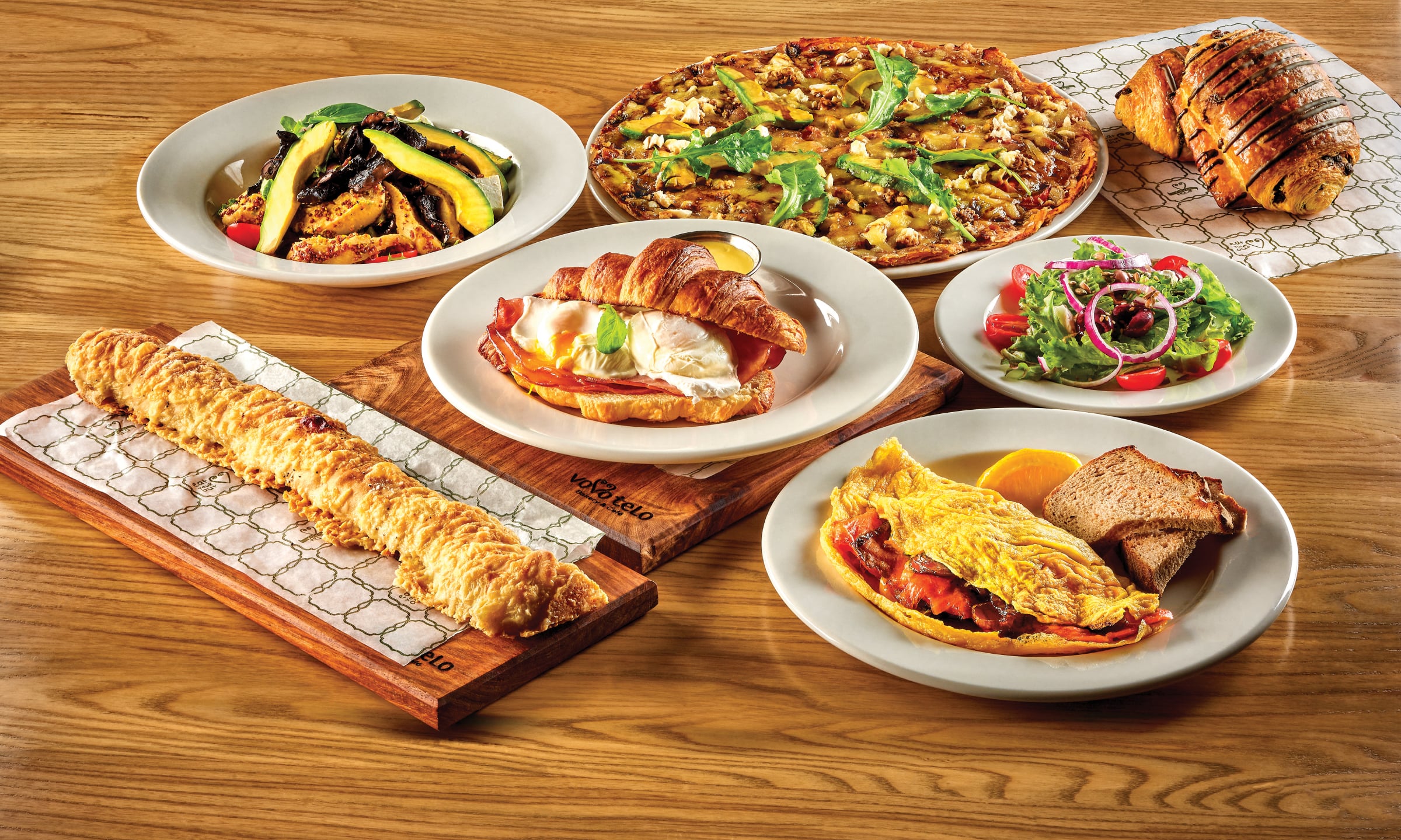 A table of Vovo Telo favourites: croissants, pizza, omelette and salad