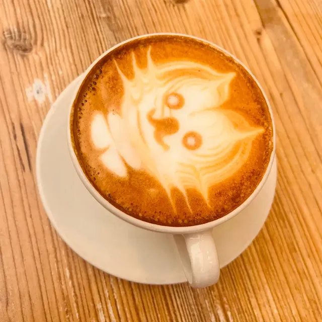 Cappuccino with cat latte art on a wooden table