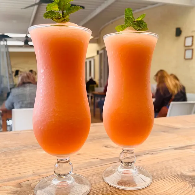 Two frozen watermelon lemonades with mint in the courtyard