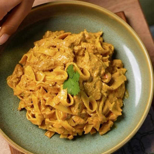 Bowl of creamy butter chicken pasta with coriander
